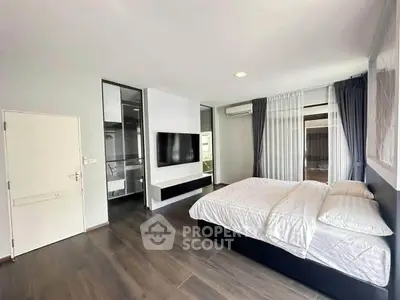 Spacious modern bedroom with sleek design and large windows for natural light.
