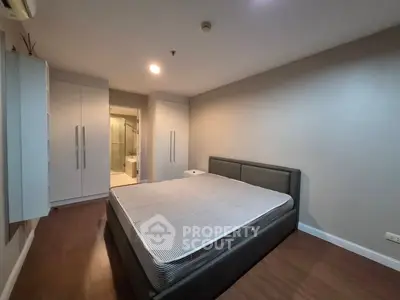 Spacious bedroom with modern design and ensuite bathroom in a stylish apartment.
