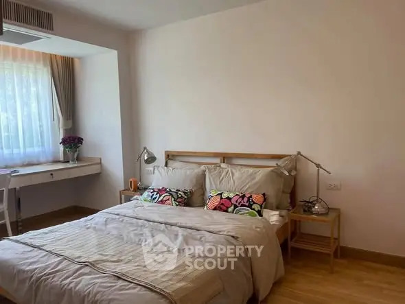 Cozy bedroom with natural light and stylish decor, perfect for relaxation.