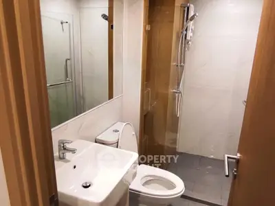 Modern bathroom with sleek fixtures and glass shower in contemporary apartment.