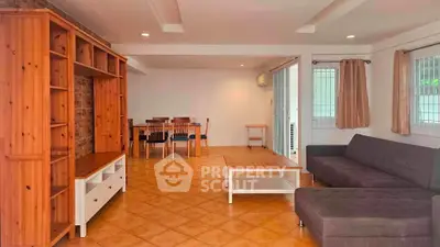 Spacious living room with wooden furniture and tiled flooring in a modern home.
