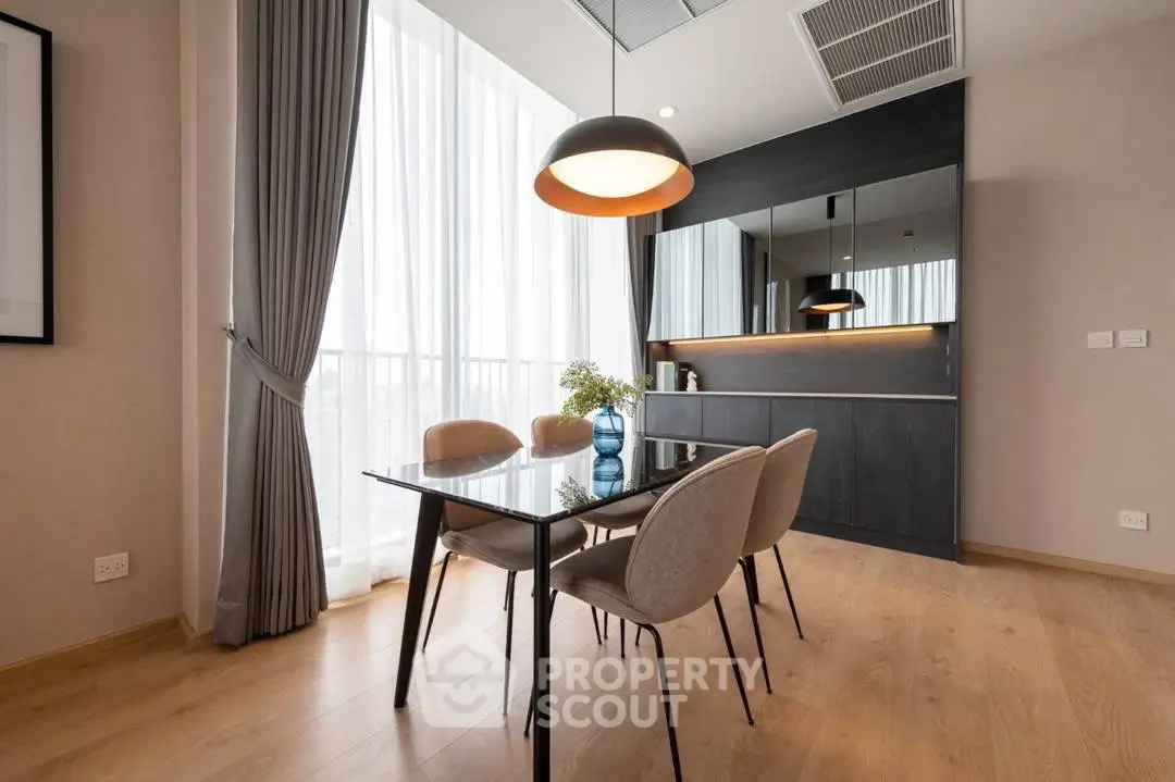 Modern dining area with elegant lighting and floor-to-ceiling windows