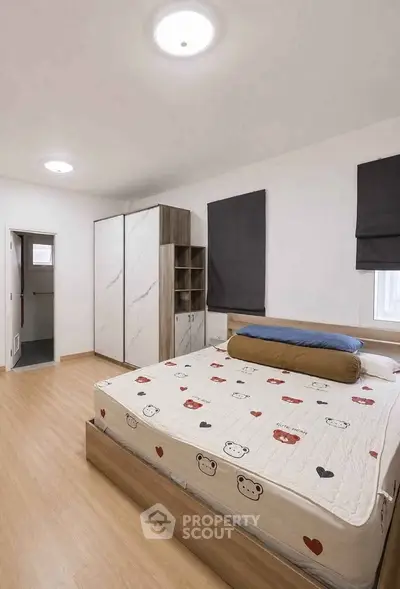 Spacious bedroom with modern decor and ample natural light, featuring a stylish wardrobe and cozy bed.