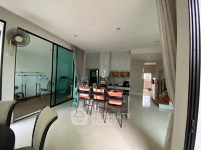 Spacious modern dining area with open kitchen and exercise space, perfect for family gatherings.