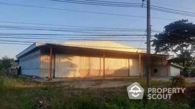 Spacious industrial warehouse with ample outdoor space and metal structure, ideal for storage or manufacturing.