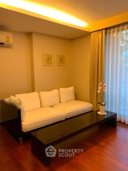 Elegant living room with modern sofa and ambient lighting, perfect for relaxation.