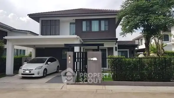 Modern two-story house with carport and landscaped front yard in a suburban neighborhood.