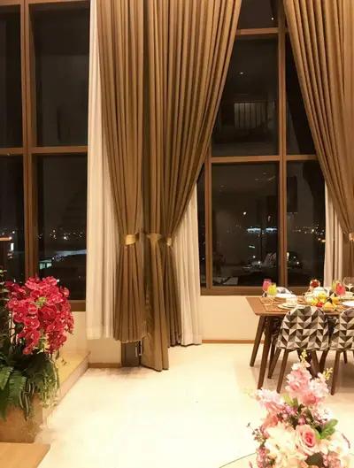 Luxurious high-ceiling living room with elegant curtains and city view, perfect for sophisticated urban living.