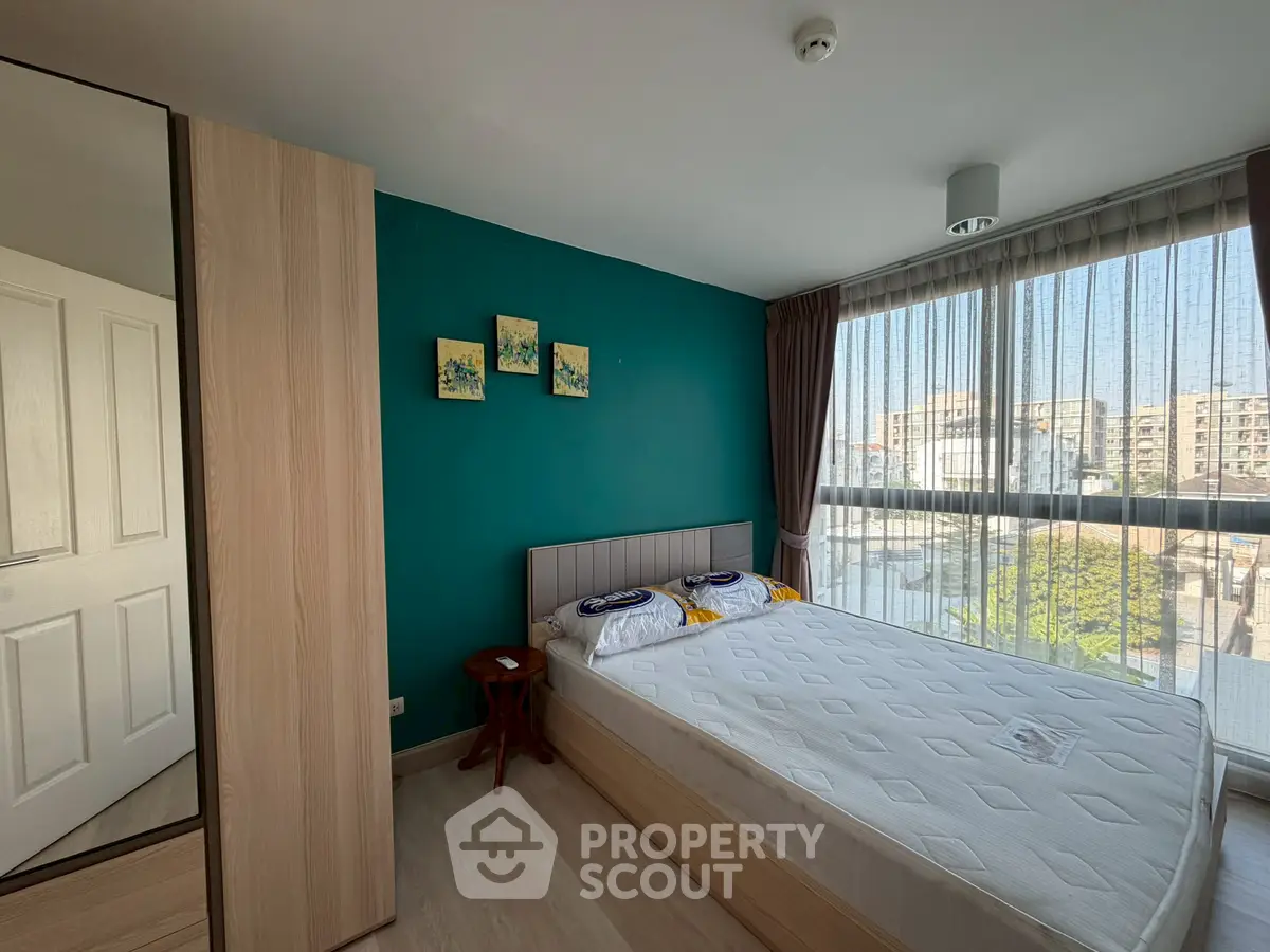 Bright bedroom with large window and modern decor in urban apartment