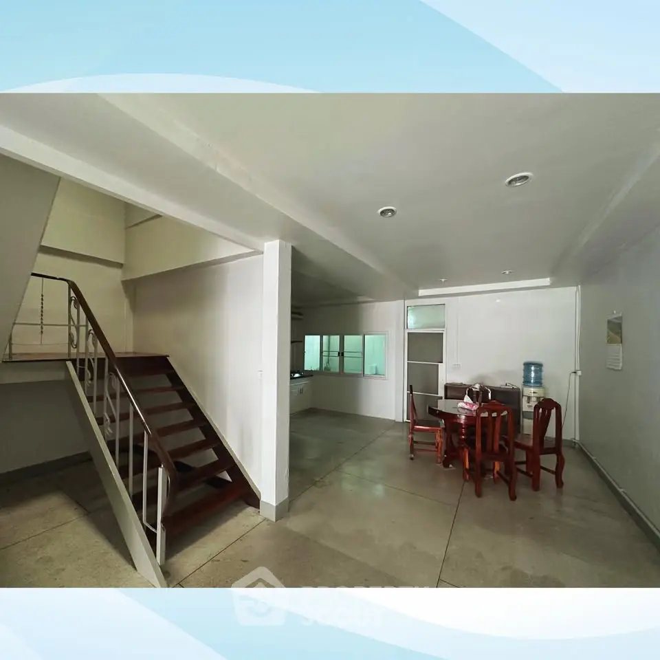 Spacious open-plan living area with modern staircase and dining set, perfect for family gatherings.