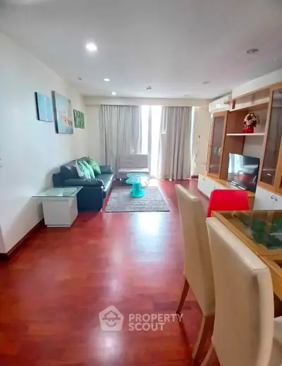 Spacious living room with modern decor and hardwood floors in a stylish apartment.