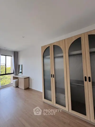 Spacious bedroom with large wardrobe and scenic window view