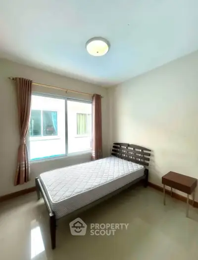 Bright bedroom with single bed and window view in modern apartment