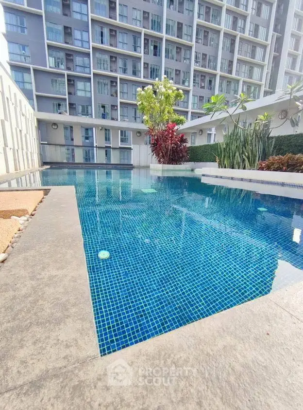 Luxurious condominium pool area with modern design and lush greenery.