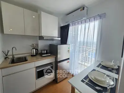 Modern kitchen with sleek appliances and dining area, offering a stunning city view through large windows.
