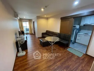 Spacious living room with modern furniture and open kitchen layout in a stylish apartment.