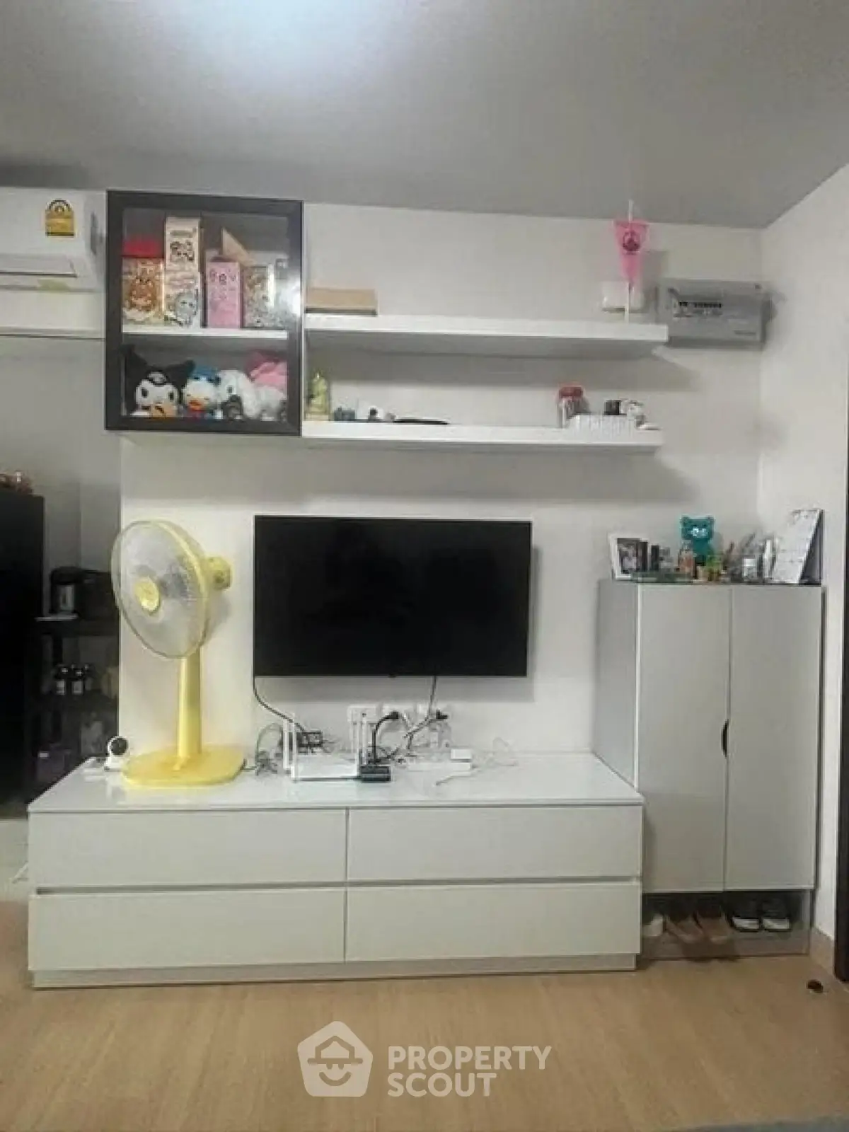 Modern living room with sleek white furniture and wall-mounted TV, perfect for cozy urban living.