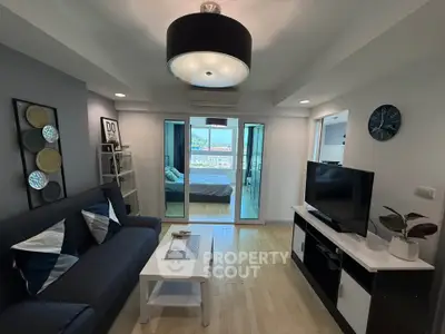 Modern living room with stylish decor and view into bedroom