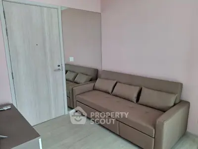 Modern living room with sleek sofa and wooden door, perfect for cozy urban living.