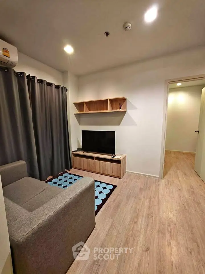 Modern living room with cozy sofa and stylish TV unit in a well-lit apartment.