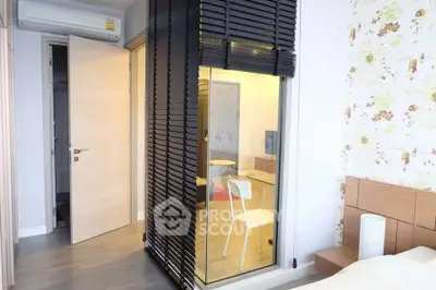Modern bedroom with stylish decor and glass partition in a contemporary apartment.