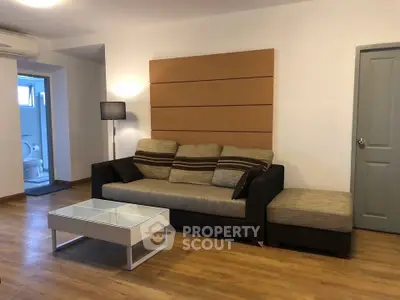 Modern living room with stylish sofa and wooden flooring in a cozy apartment.