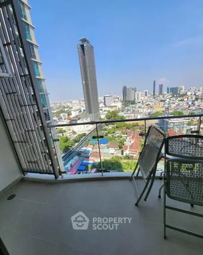 Stunning cityscape view from modern high-rise balcony with sleek glass railing.