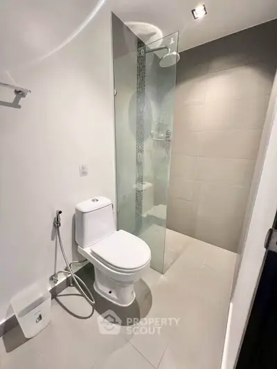 Modern bathroom with sleek shower and toilet in contemporary apartment.