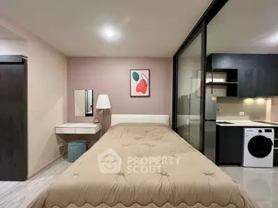 Modern studio apartment with cozy bedroom and compact kitchen featuring a washing machine.