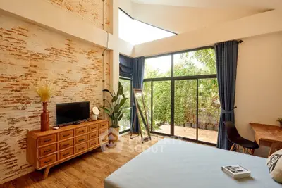 Spacious bedroom with rustic brick wall, large windows, and modern decor