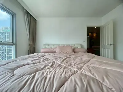 Cozy bedroom with large window and soft pink bedding in modern apartment