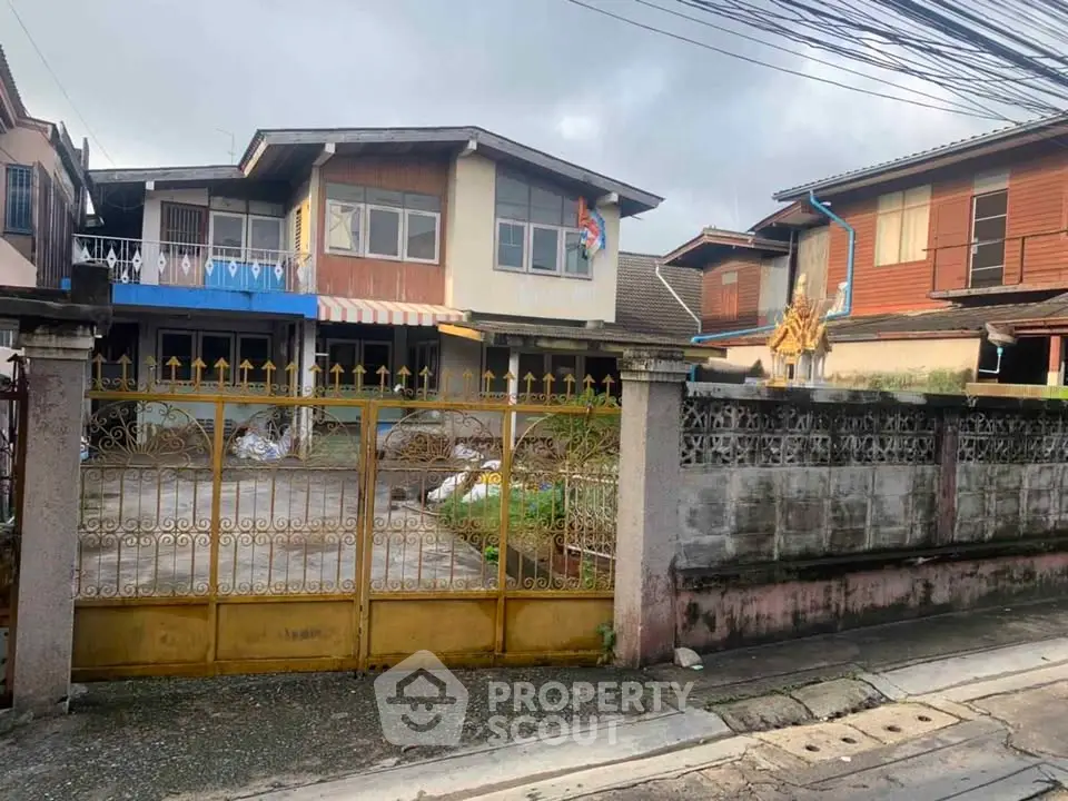 Charming two-story house with gated entrance and spacious driveway in a serene neighborhood.