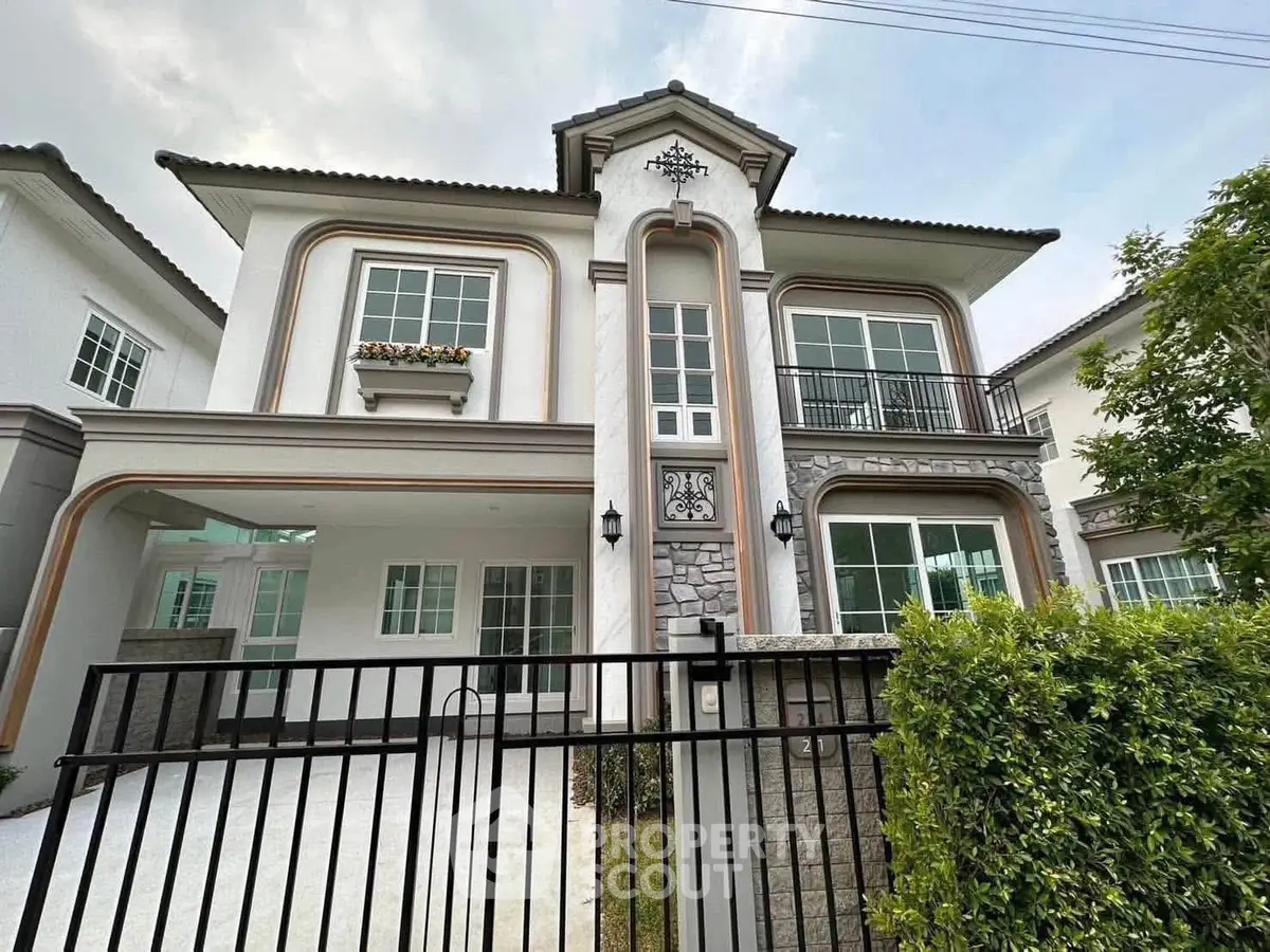 Elegant two-story house with classic architecture and lush greenery, perfect for family living.