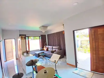 Spacious living room with modern decor and large windows opening to a garden view.