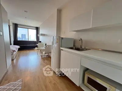 Modern studio apartment with open layout, featuring a cozy living area and compact kitchen.