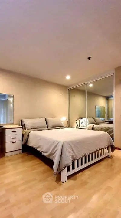 Spacious bedroom with mirrored closet and cozy lighting in modern apartment.