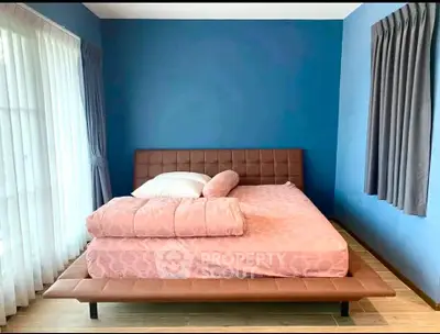 Modern bedroom with stylish blue walls and elegant brown leather bed frame.