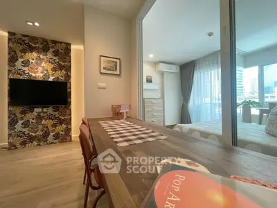 Modern open-plan living room with stylish decor and city view, featuring a cozy dining area and bedroom access.