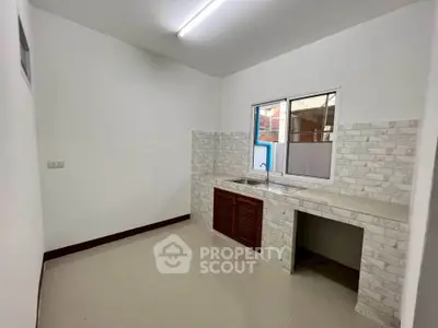 Modern kitchen with tiled backsplash and large window, perfect for culinary enthusiasts.