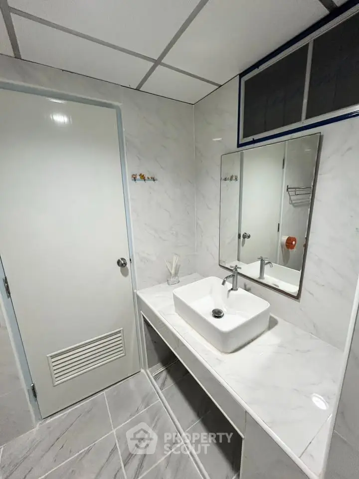 Modern bathroom with sleek white marble finishes and stylish sink design.