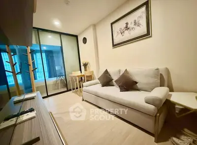 Modern living room with stylish decor and glass partition in a cozy apartment.