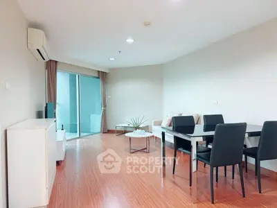 Spacious living room with modern dining area and balcony access