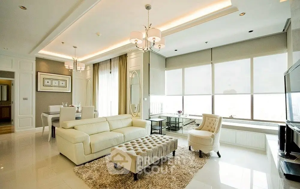 Luxurious modern living room with elegant furniture and large windows offering natural light.