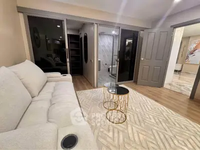 Modern living room with elegant sofa and stylish coffee table, featuring open access to a luxurious bathroom.