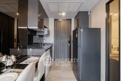 Modern kitchen with sleek design, featuring a dining area and stainless steel appliances.