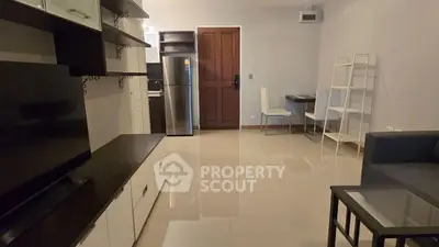 Modern living room with sleek furniture and stainless steel appliances.