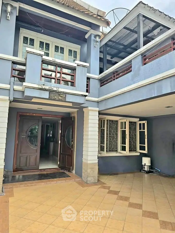 Charming two-story home with spacious balcony and elegant entrance in serene neighborhood.