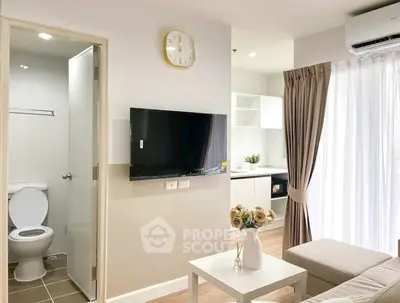 Modern apartment interior with open living room and kitchen, featuring wall-mounted TV and elegant decor.