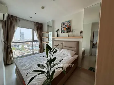 Modern bedroom with city view, featuring stylish decor and large window for natural light.