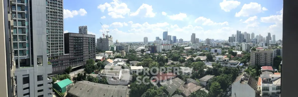 Panoramic cityscape view from a high-rise building showcasing urban skyline and residential areas.